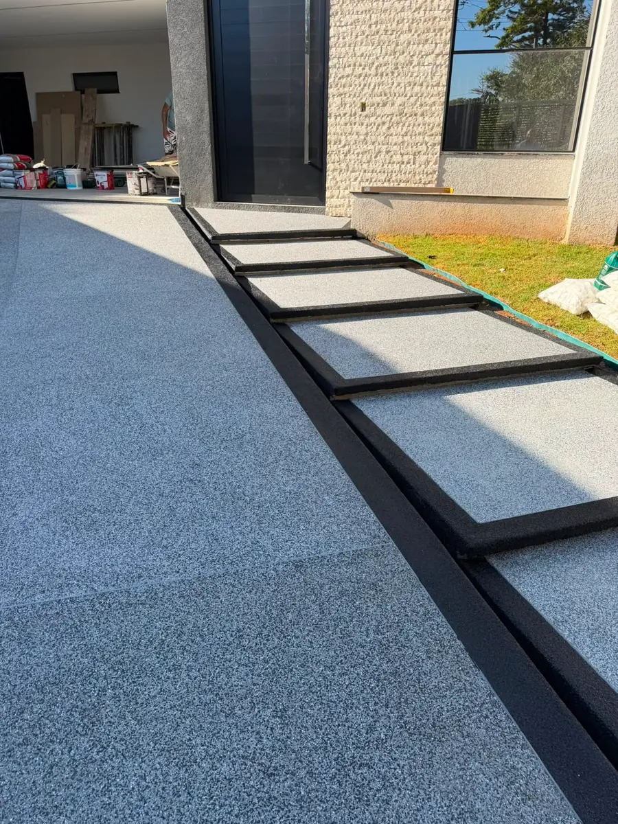 Entrada de residência com piso de Fulget cinza e faixas de dilatação